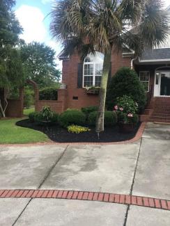 Black Rubber Mulch Landscaping Around Brick House